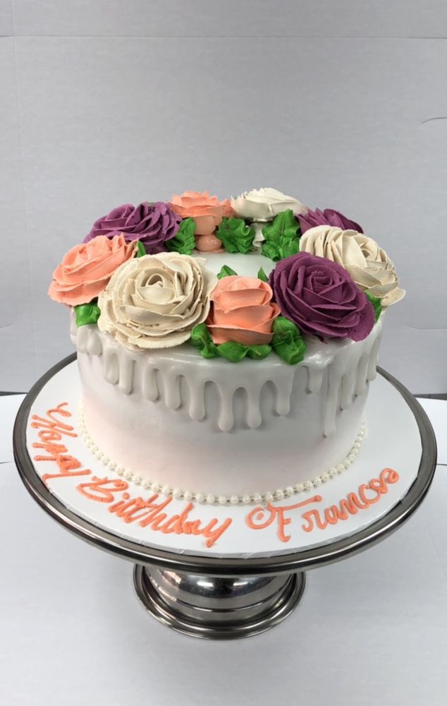 Cupcakes decorated with flowers beside a cake